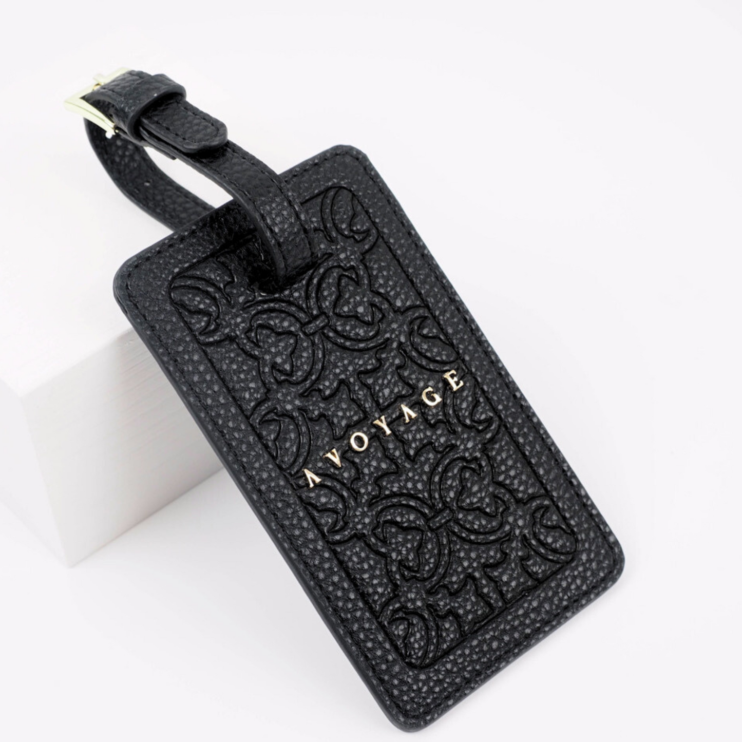 Zwart label voor aan de koffer voor persoonlijke gegevens. Het label heeft een goud logo en is voorzien van een mooie print die in het materiaal is gedrukt.